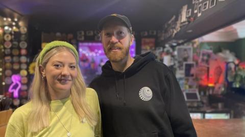 Married couple in front of bar