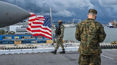 US soldiers holding a flag on a ship