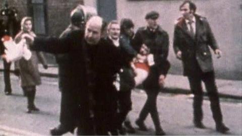 Fr Edward Daly waves a white handkerchief as Jackie Duddy is carried away on Bloody Sunday, 30 January 1972