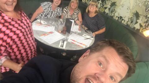 James Corden taking a selfie with Andrea Rusted and three work colleagues