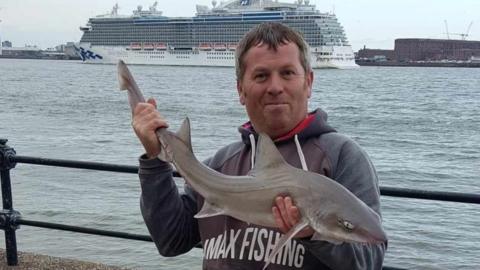 Damian Owens with a species of smooth hound shark he caught in the Mersey