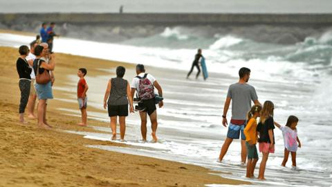 People on the beach of La Centrale in warm weather, in Hossegor, southwestern France, on 27 October 2022