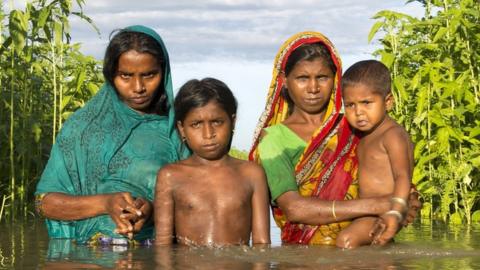 Family in floodwater in Bangladesh