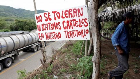 A sign reads: "We do not tolerate nor accept drug cartels in our territory" at a checkpoint in Mexico