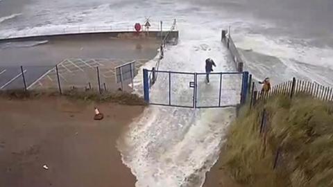 Three people almost get caught in a wave