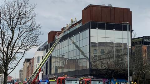 Firefighters dampening a fire at Babel Belfast