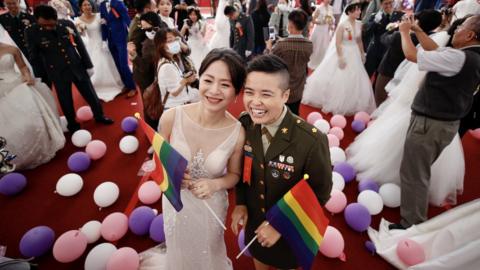 Couple Yi Wang (R) and Yumi Meng (L) react during a military mass wedding in Taoyuan, Taiwan, 30 October 2020