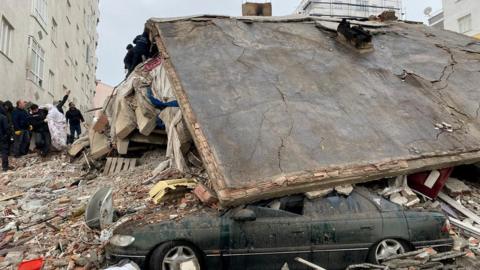 A car buried by the roof of a house