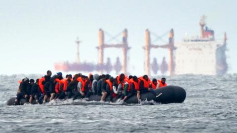 A group of people thought to be migrants crossing the Channel in a small boat traveling from the coast of France and heading in the direction of Dover, Kent, pictured on 29 August 2023