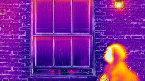 Image of woman and house using thermal camera