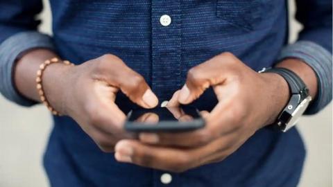 An anonymous man using his smartphone.