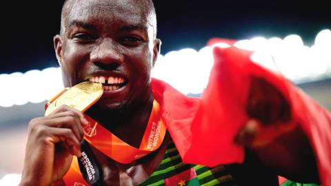 Hugues Fabrice Zango celebrates by biting his gold medal after winning the triple jump at the World Athletics Championships in Budapest, Hungary, in August 2023