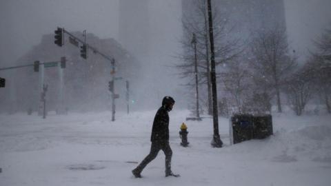 A lone man walks on Atlantic Ave. during the snowstorm in downtown Bosto