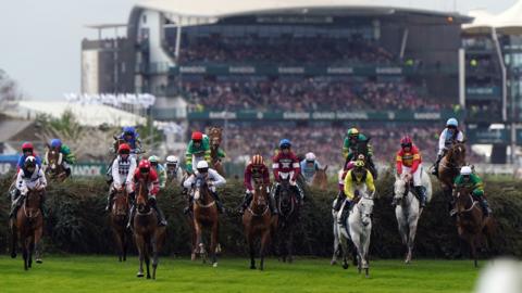 Horses jump a fence during the Grand National