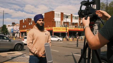 A teenager stood in Luton in front of a camera and microphone