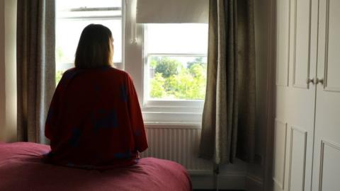 Person sitting in a room alone