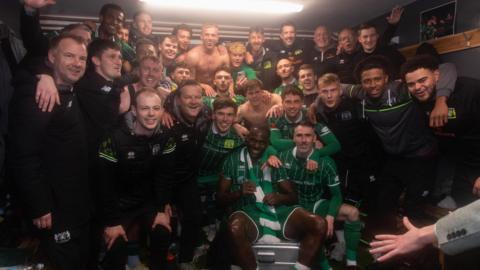 Yeovil players and staff gather together in the dressing room