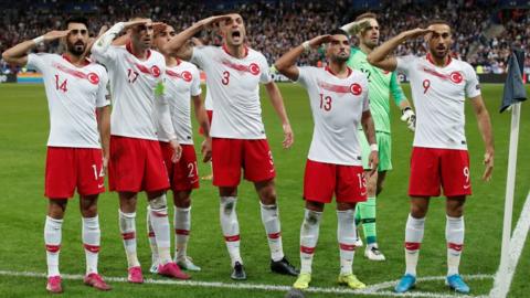 Turkey players salute after Kaan Ayhan celebrates scoring their first goal