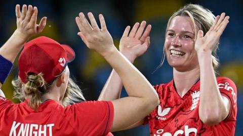 Heather Knight (L) and Lauren Bell (R) high-five after Bell takes a wicket for England against West Indies