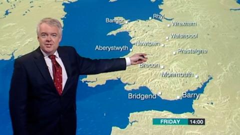 Carwyn Jones in front of a BBC weather map
