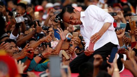 Indonesia's presidential candidate for the upcoming general election Joko Widodo takes pictures with his supporters during his first campaign rally at a stadium in Serang, Banten province, Indonesia, March 24, 2019