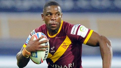 Jermaine McGillvary holds the ball in a game for Huddersfield