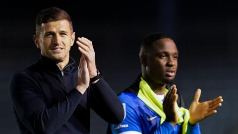 Pompey boss John Mousinho applauds fans whilst leaving the field at Fratton Park following their dominant win over League Two Gillingham in the group stages of the EFL Trophy.