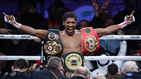 Anthony Joshua celebrates with his belts in the ring after beating Andy Ruiz Jr.