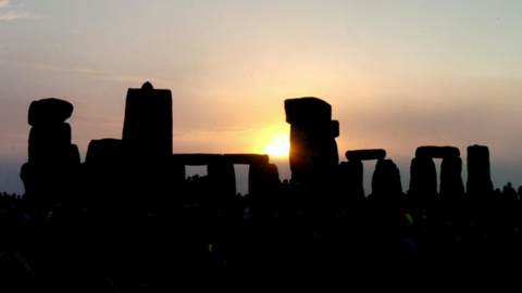 Stonehenge stones silhouetted in front of the sunrise