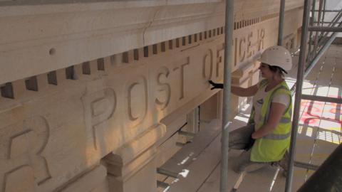 Katie May Langridge in front of carving saying post office, Lowestoft