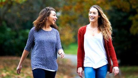 Two women walking in a park