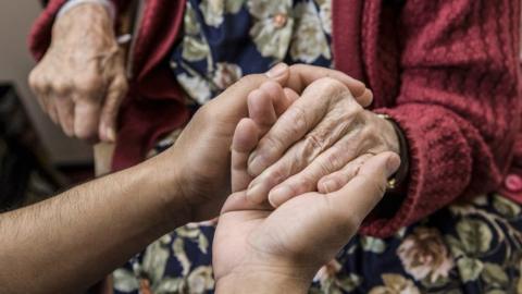 Holding an older person's hand