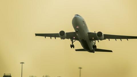 An aircraft takes off in the early morning haze at RAF Brize Norton, Oxfordshire