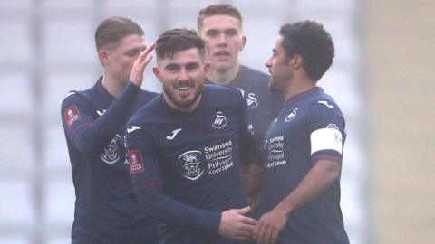 Wayne Routledge (R) is congratulated by his Swansea team-mates