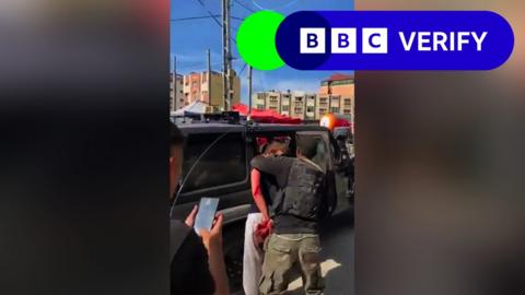 Bloodied woman taken into jeep