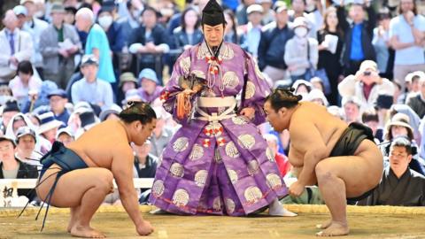 This picture taken on April 15, 2019 shows sumo wrestlers taking part in a "honozumo," a ceremonial sumo exhibition, on the grounds of Yasukuni Shrine in Tokyo.