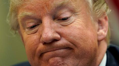 President Donald Trump looks down while speaking to reporters about healthcare