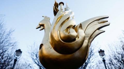 A golden copper weathervane in the shape of a rooster scene before being fitted to the new spire of Notre-Dame cathedral.