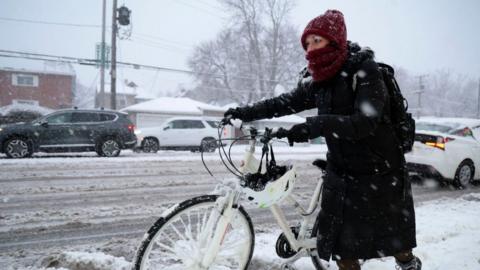 Rebecca Zimmerman moves along Harlem Avenue on her way to work in Oak Park from Forest Park as a winter storm hits the Chicago area with heavy snow and near-blizzard conditions