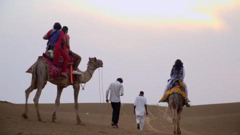 Tourists on camels in India's Thar desert