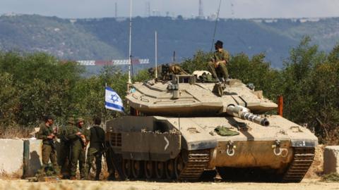 Israeli troops and a tank deployed near Israeli's border with Lebanon (16 October 2023)