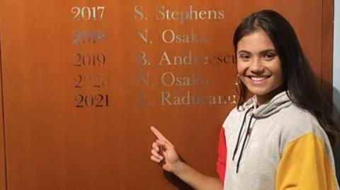 Emma Raducanu with her name on the US Open honours board