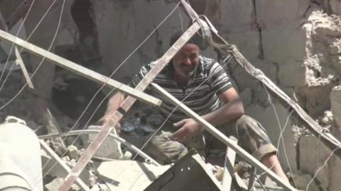 A man sifts through rubble in Aleppo Syria