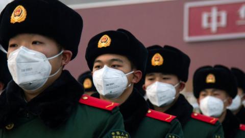 Chinese policemen wearing face masks