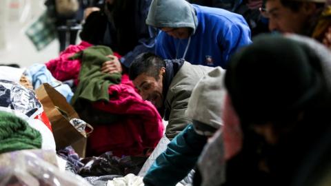 A homeless man smiles as he picks out some new clothes at the River Plate stadium, Buenos Aires. 3 July 2019