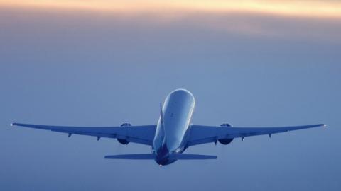 An airliner in flight, seen from behind