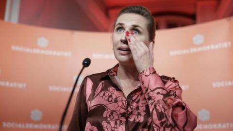 Danish Prime Minister Mette Frederiksen wipes a tear from her eye during her victory speech on election results night in Christiansborg, Copenhagen, Denmark