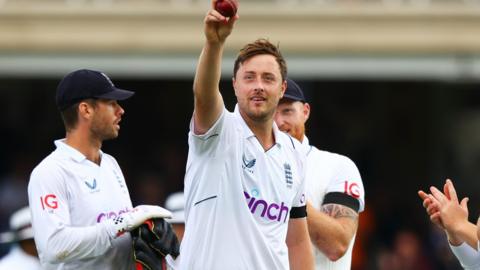 England bowler Ollie Robinson holds up the ball to the crowd after taking a five-wicket haul