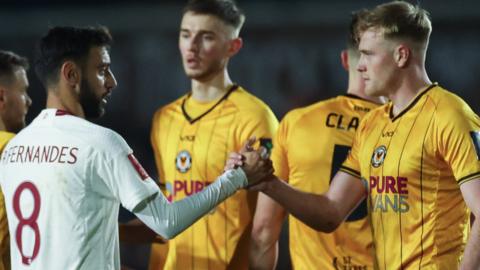 Will Evans of Newport County (R) shakes hands with Bruno Fernandes of Manchester United after the final whistle