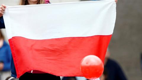 Woman holding a Polish flag